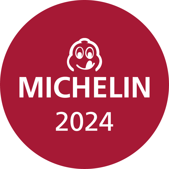 Runder roter Hintergrund mit dem Text "MICHELIN 2024" in weißer Schrift und einem lächelnden Michelin-Männchen darüber.