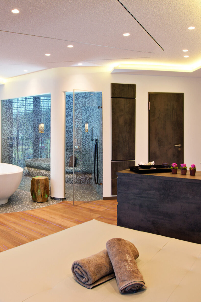 Zwei zusammengerollte Handtücher liegen auf einem Tisch im Wellnessbereich eines Luxushotels.
