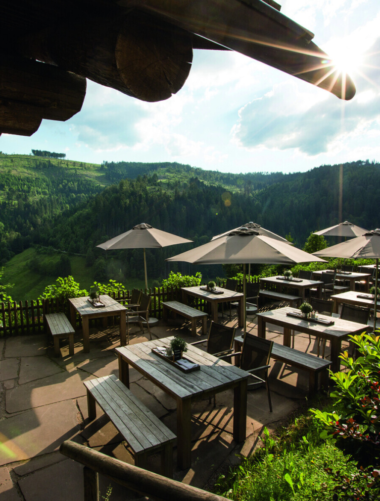 Sonnenterrasse an der Blockhütte im Luxushotel Traube Tonbach – Panorama-Ausblick über die Schwarzwaldlandschaft.
