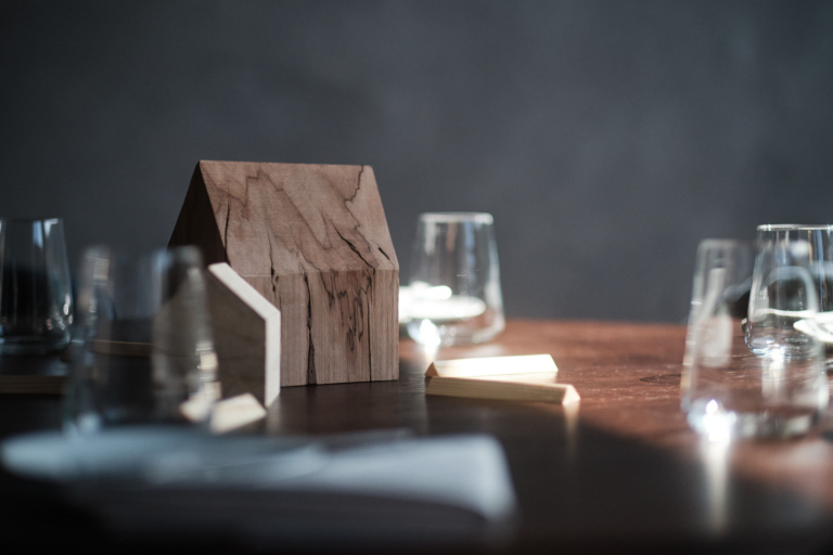 Minimalistische Tischdekoration mit Holzhaus – modernes Fine Dining Detail im Luxushotel Traube Tonbach Schwarzwald.