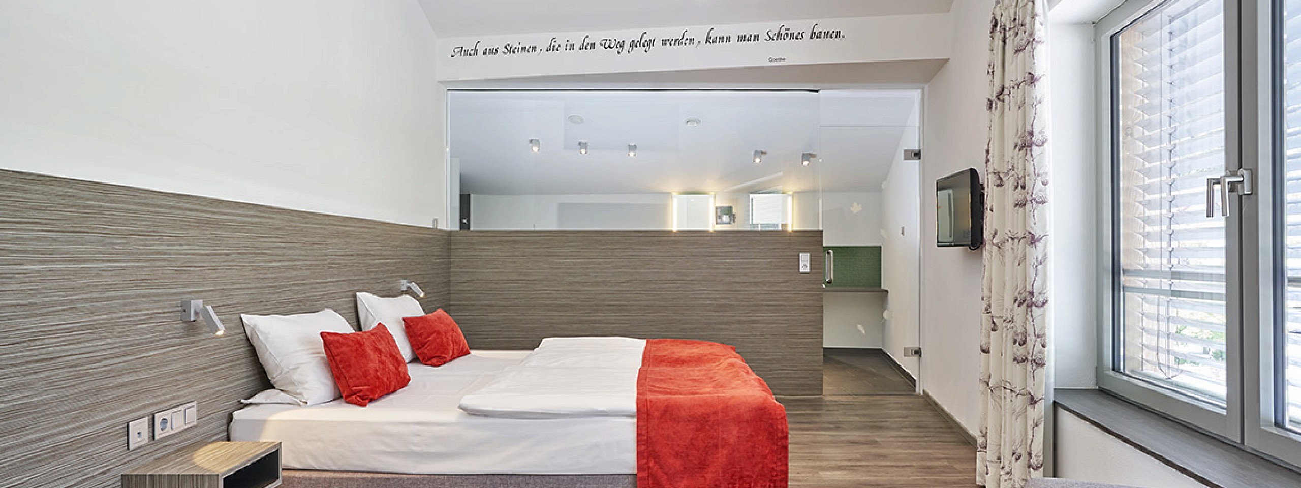 Edles Hotelzimmer im Schwarzwald mit langer Eckbank und prächtigen Holzmöbeln sowie Kronleuchter.