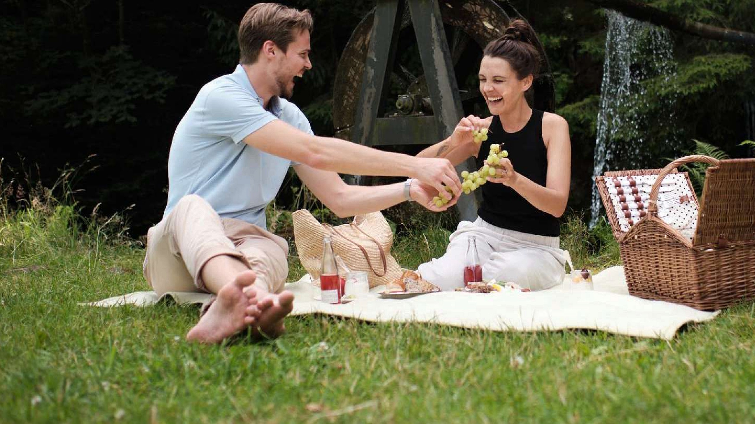 Ein junges Paar genießt ein Picknick nahe dem 5 Sterne Superior Hotel im Schwarzwald.