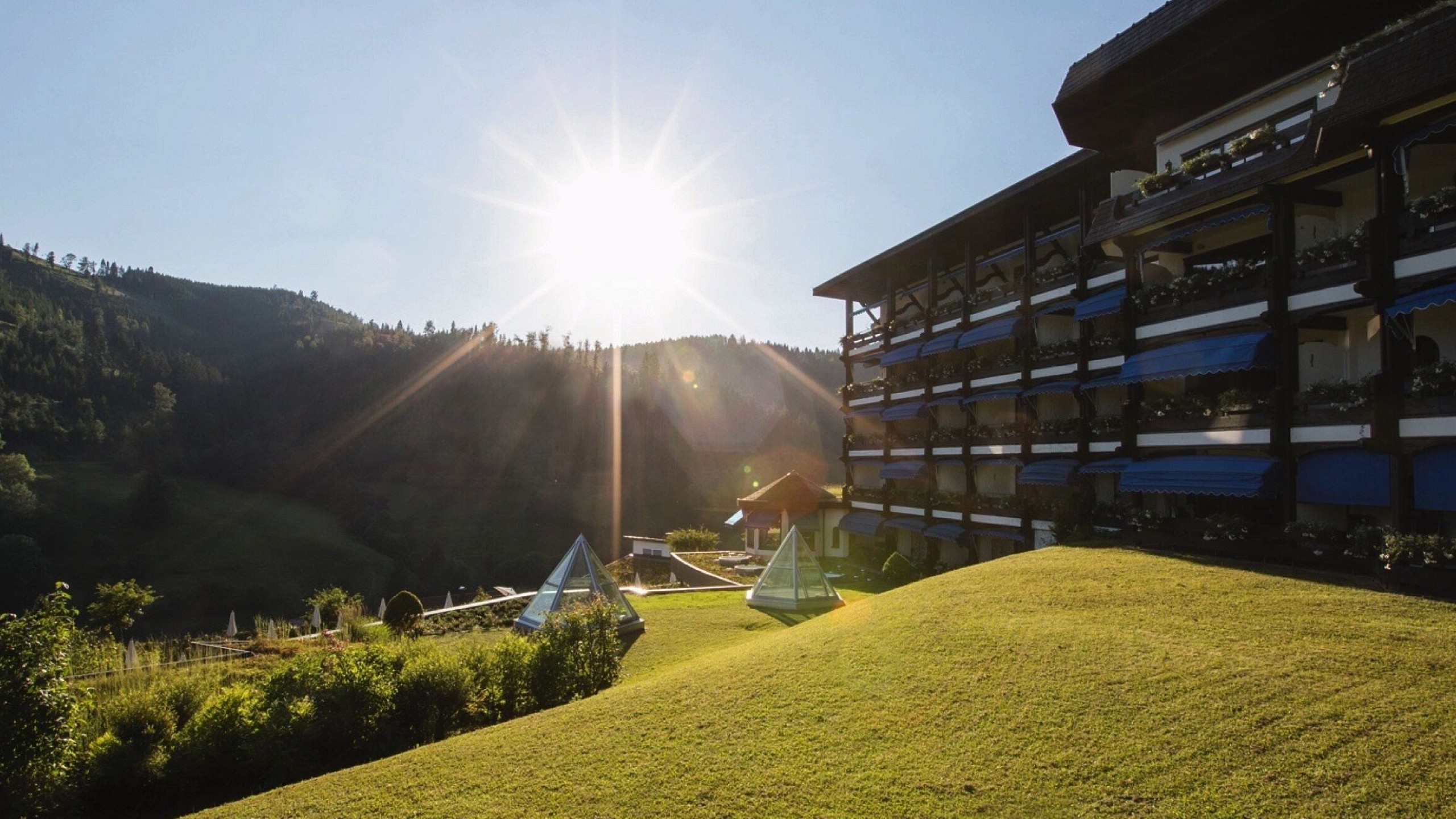 Blick auf die Fassade und den Außenbereich des Hotels mit verschiedenen Arrangements im Schwarzwald.
