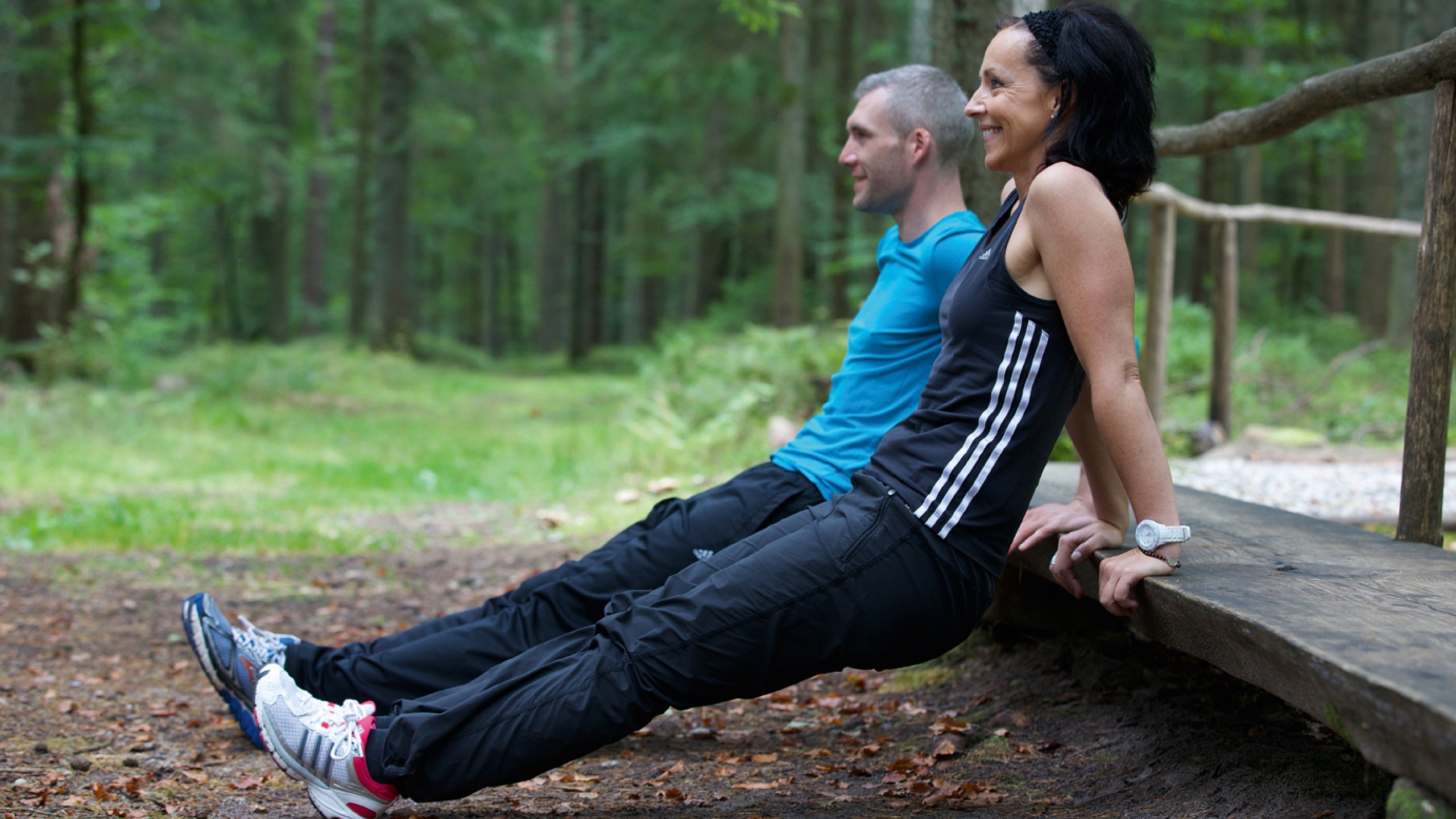 Eine junge Frau und Mann treiben Sport im Freien nahe dem Familienhotel im Schwarzwald.