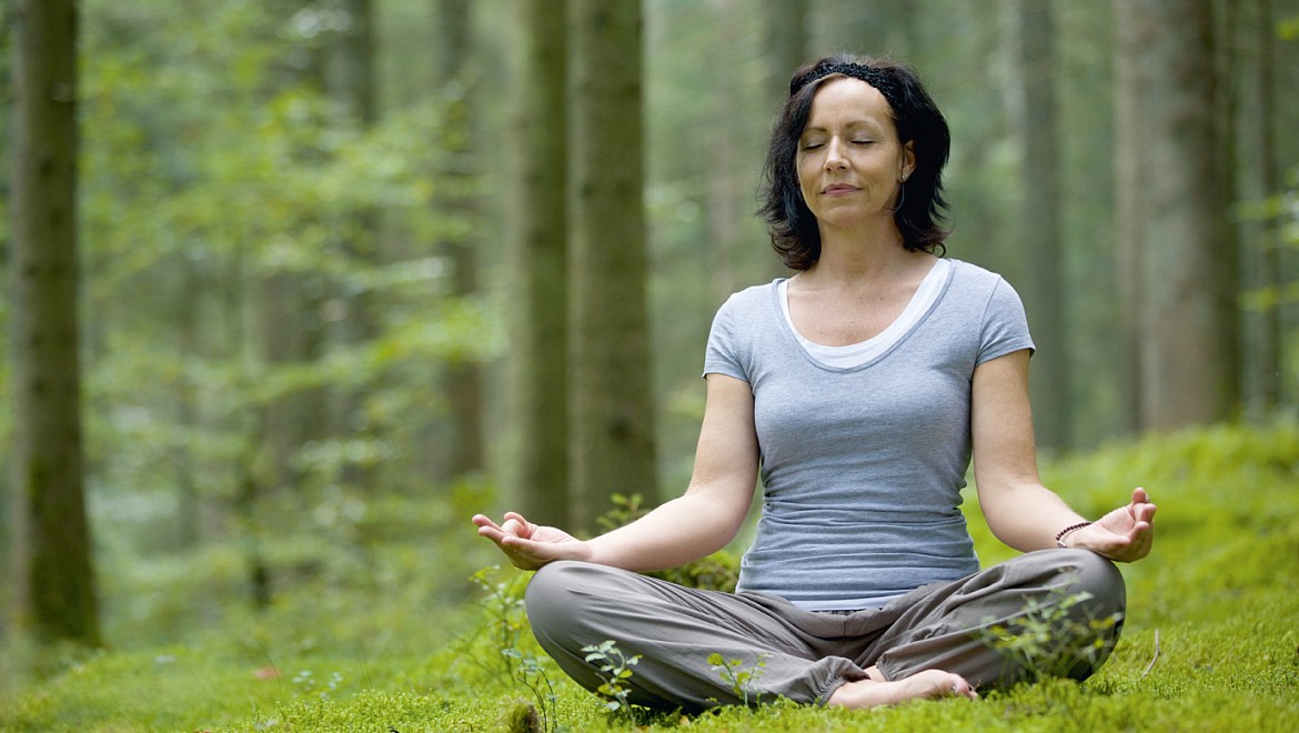 Am Familienhotel im Schwarzwald praktiziert Yoga-Lehrerin Iris Mahler im Freien eine Yoga-Position.