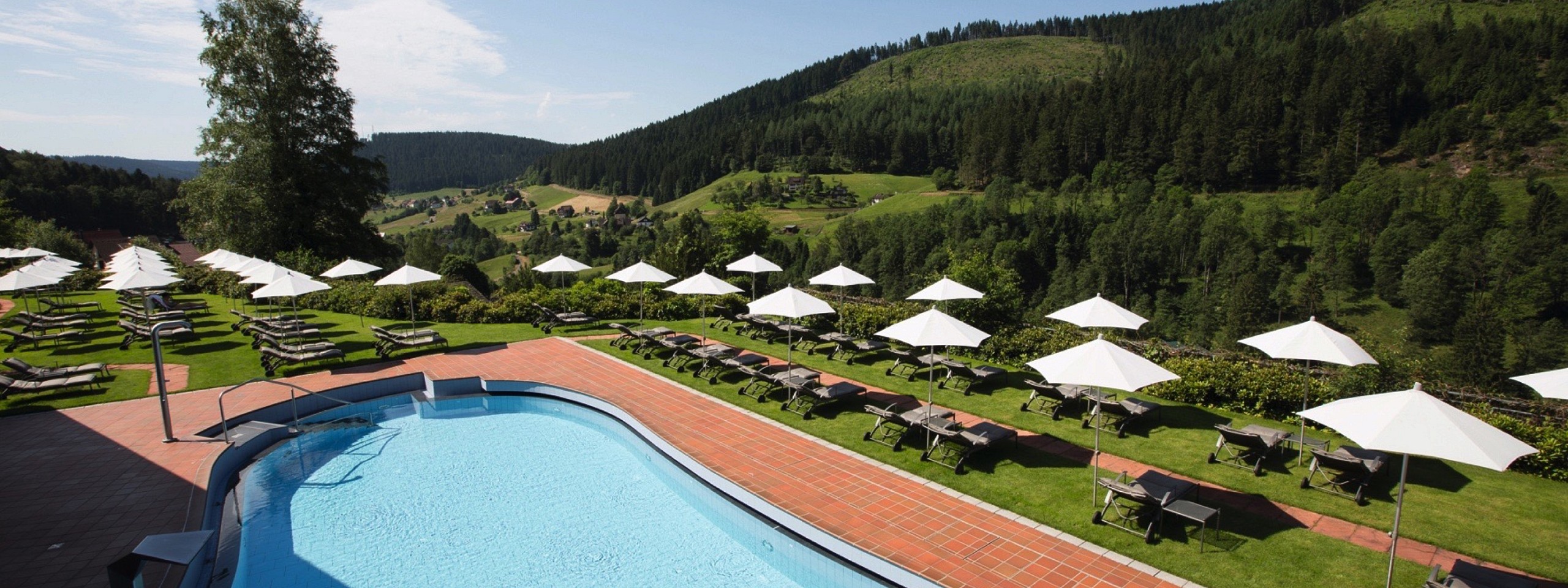 Großer Poolbereich mit Liegen im Hotel mit Arrangements im Schwarzwald.