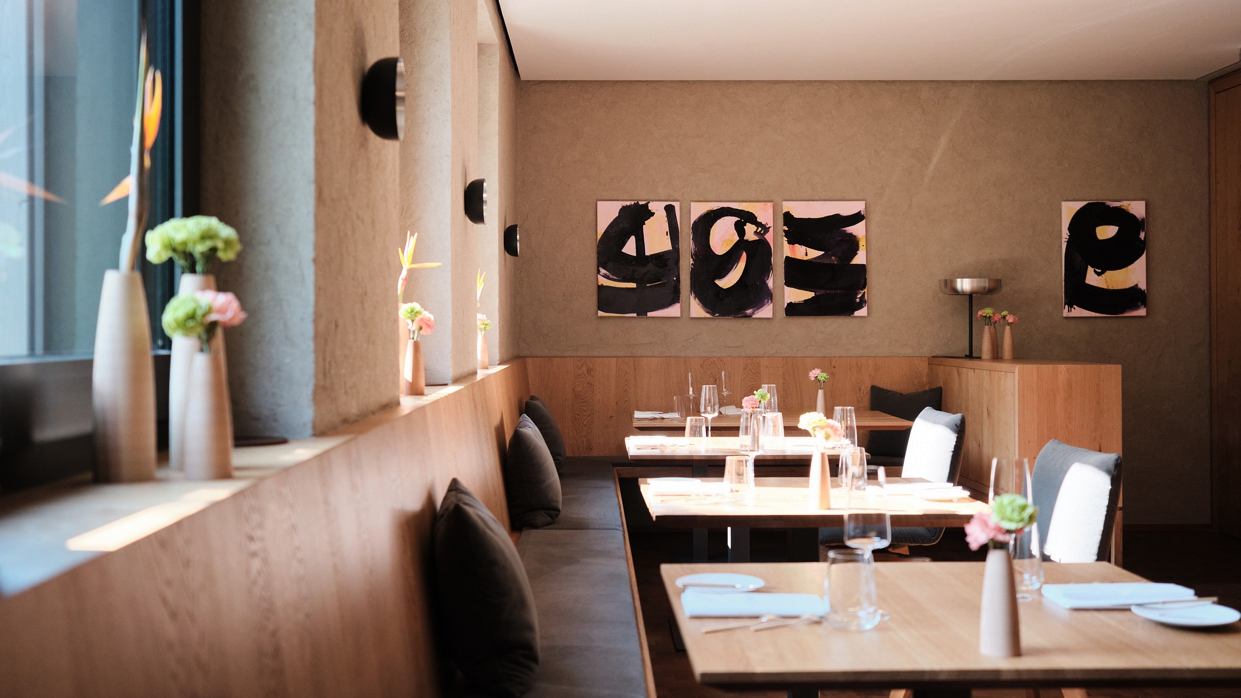 Stilvolles Sterne Restaurant im Schwarzwald mit hölzerner Eckbank und abstrakten Wandbildern.