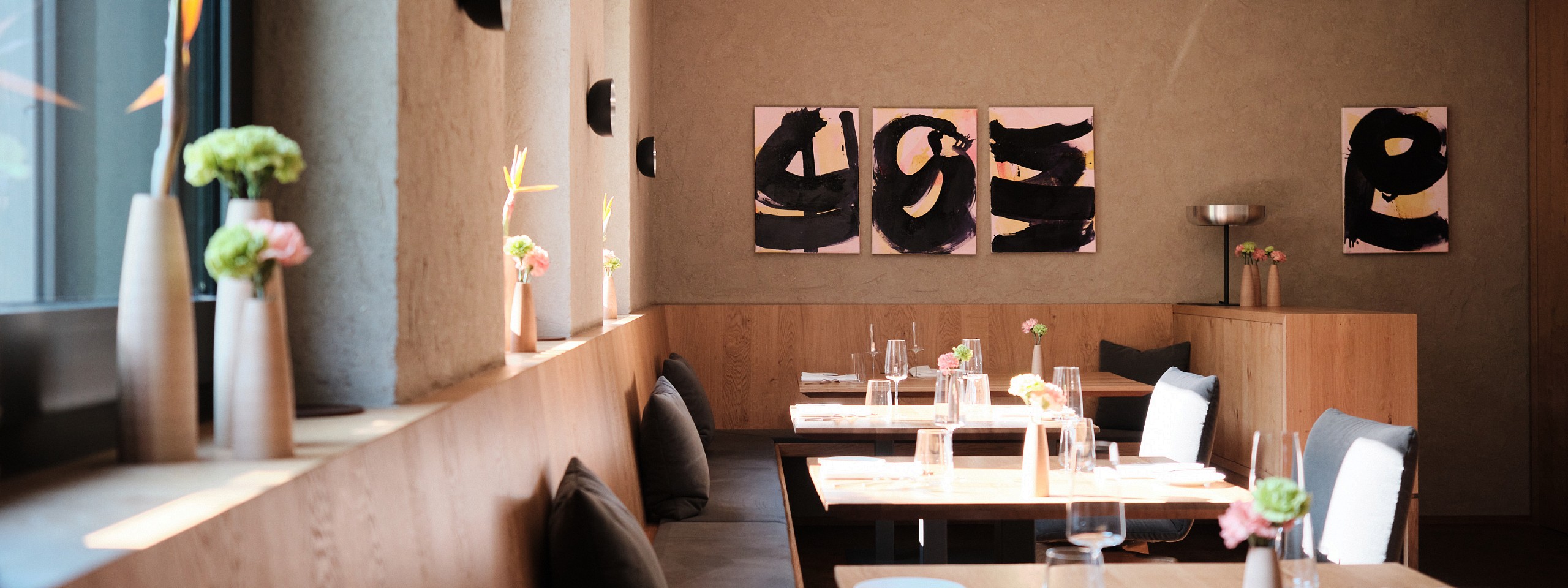 Stilvolles Sterne Restaurant im Schwarzwald mit hölzerner Eckbank und abstrakten Wandbildern.
