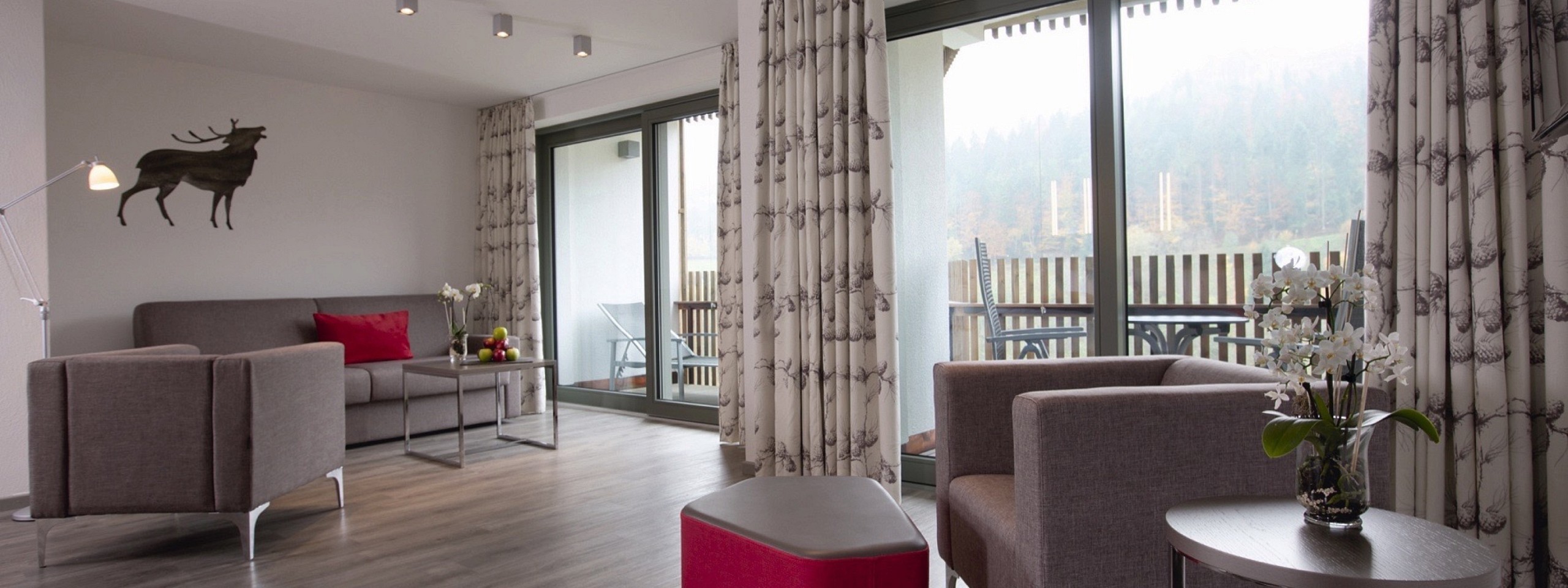 Geräumiges Zimmer mit Sitzmöglichkeiten und Balkon im Hotel mit Arrangements im Schwarzwald.