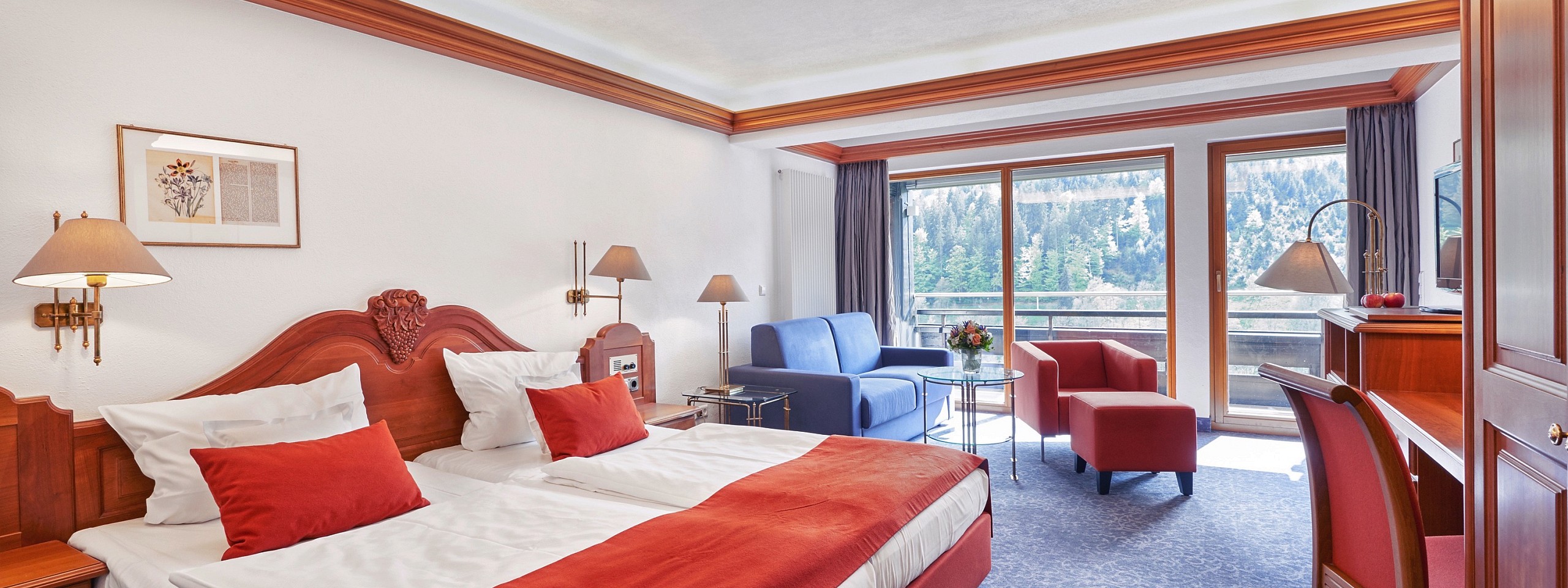 Einladend eingerichtetes Hotelzimmer im Schwarzwald mit Doppelbett und Sitzmöbeln.