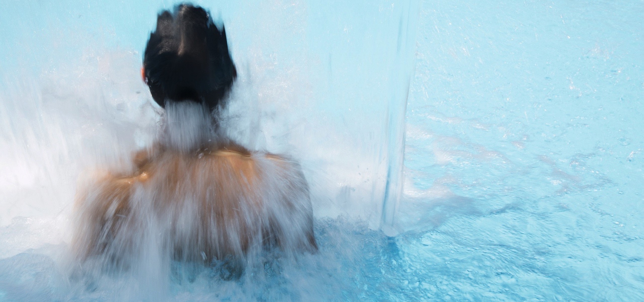 Wasser des Wasserfalls im Pool nahe dem Restaurant in Baiersbronn prallt auf eine junge Frau.